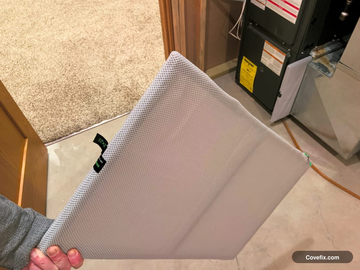 A pleated HVAC filter being checked before reinstalling