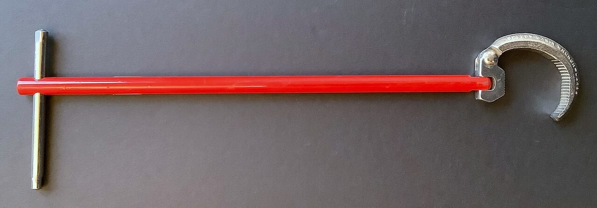 A telescoping basin wrench with a red shaft and a curved jaw