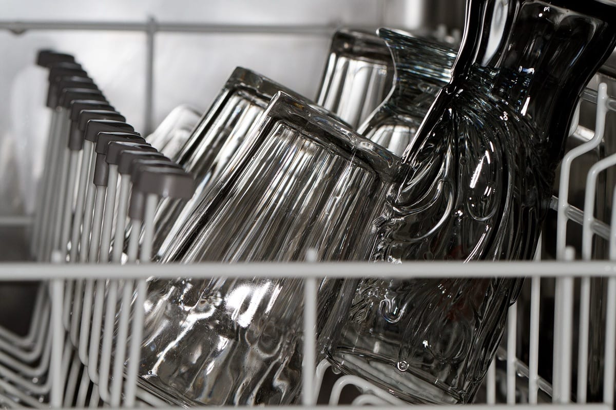 Glasses stacked upside down in a dishwasher rack