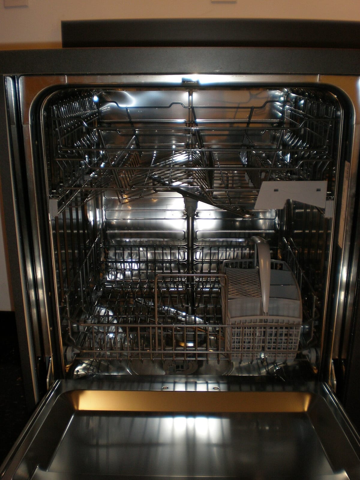 The stainless interior of an empty dishwasher with both racks in place