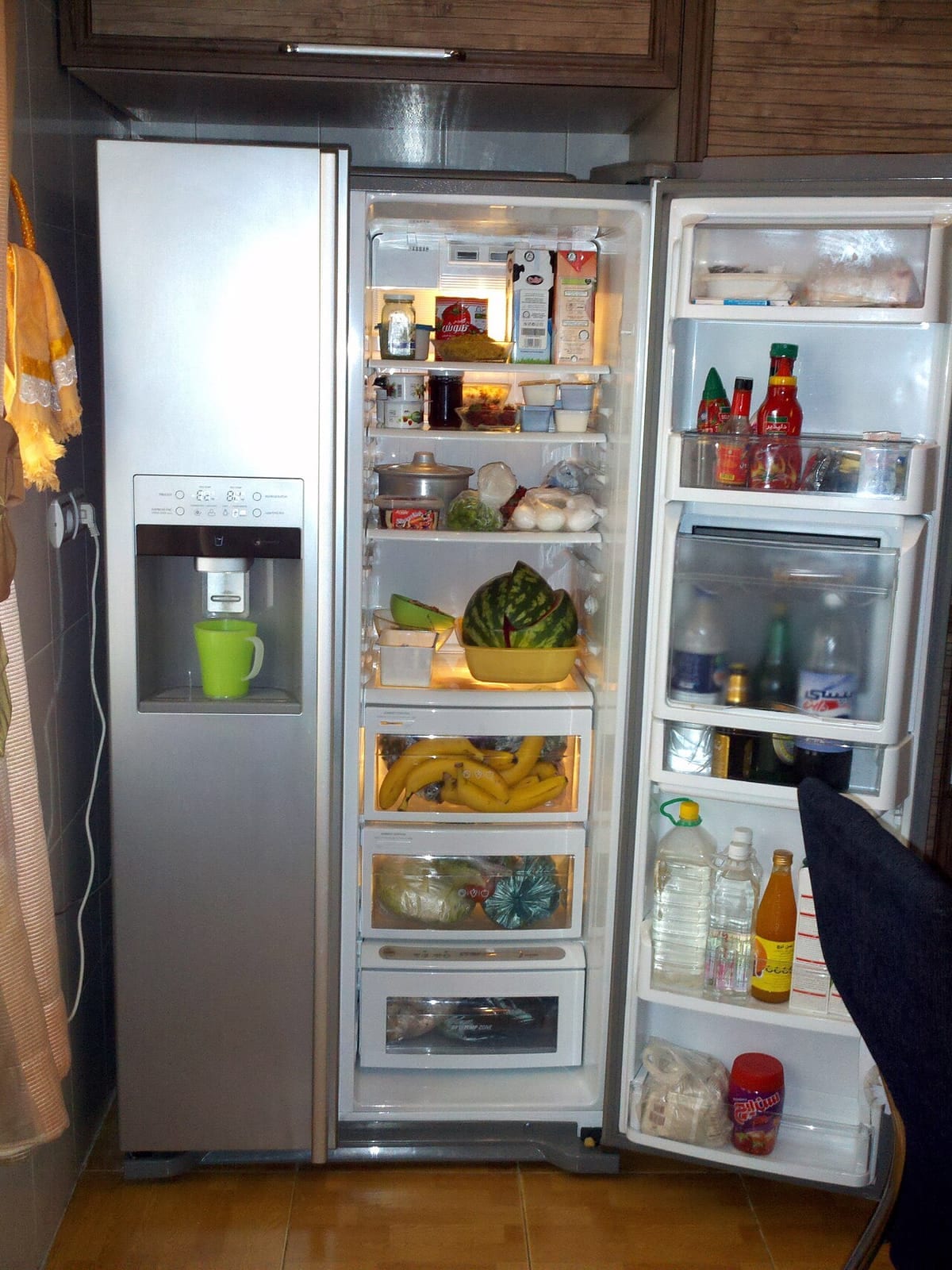 An open refrigerator with stocked shelves and drawers at the bottom