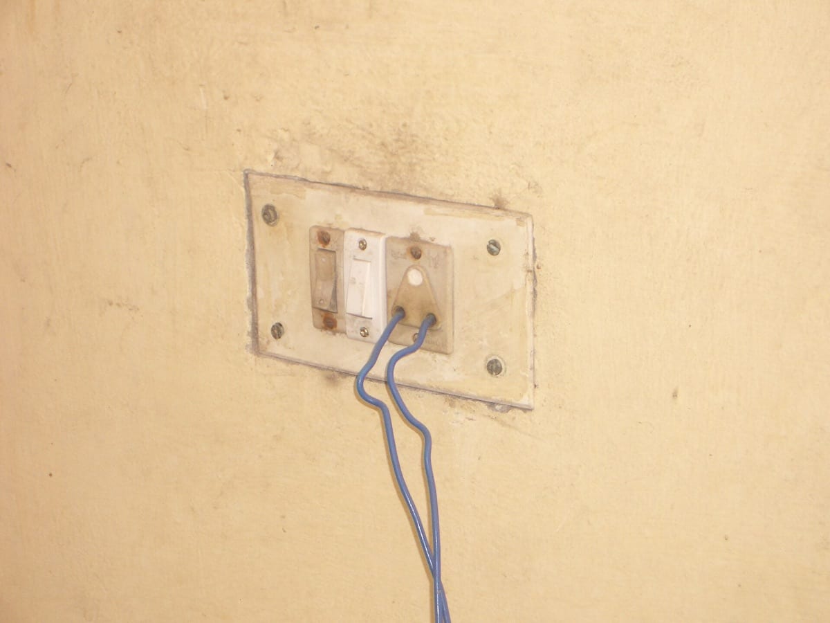 Old light switches on a wall with exposed wiring