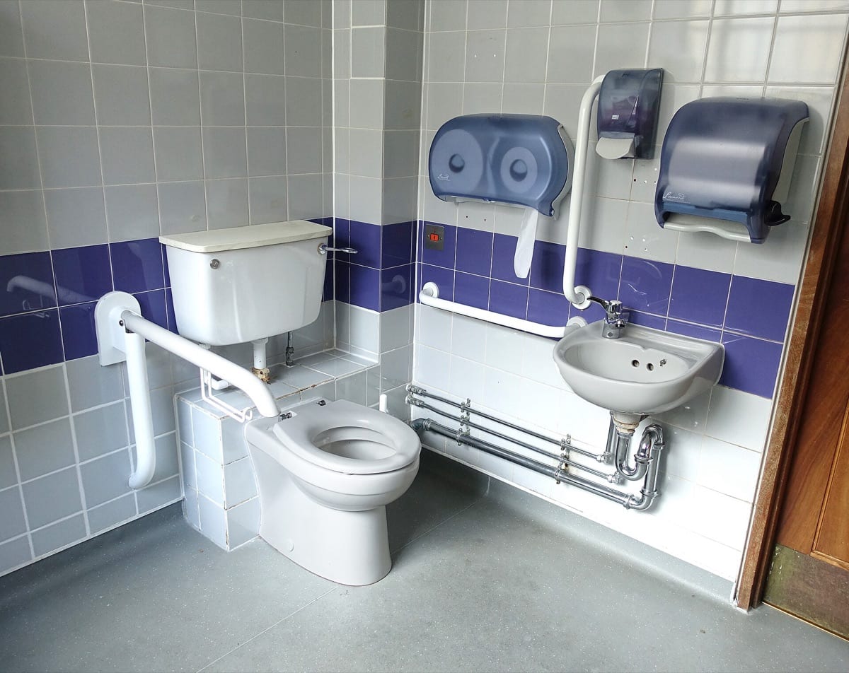 A white toilet with its cistern, seen from the side