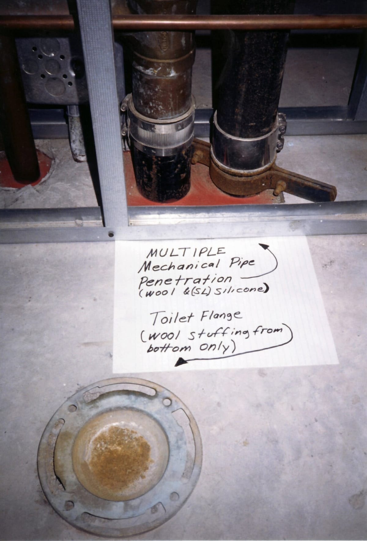 A bare toilet flange set in a concrete floor, ready for a wax ring