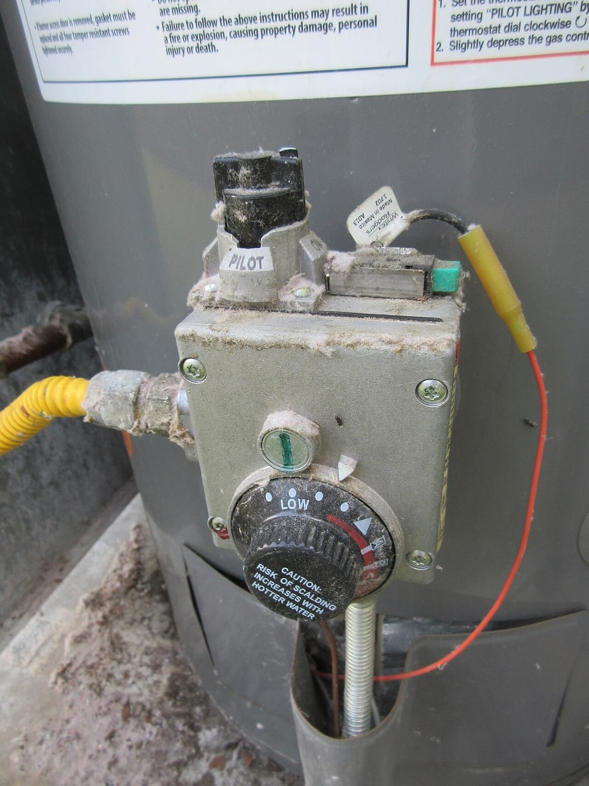 The gas control valve on a residential water heater, with the pilot setting visible