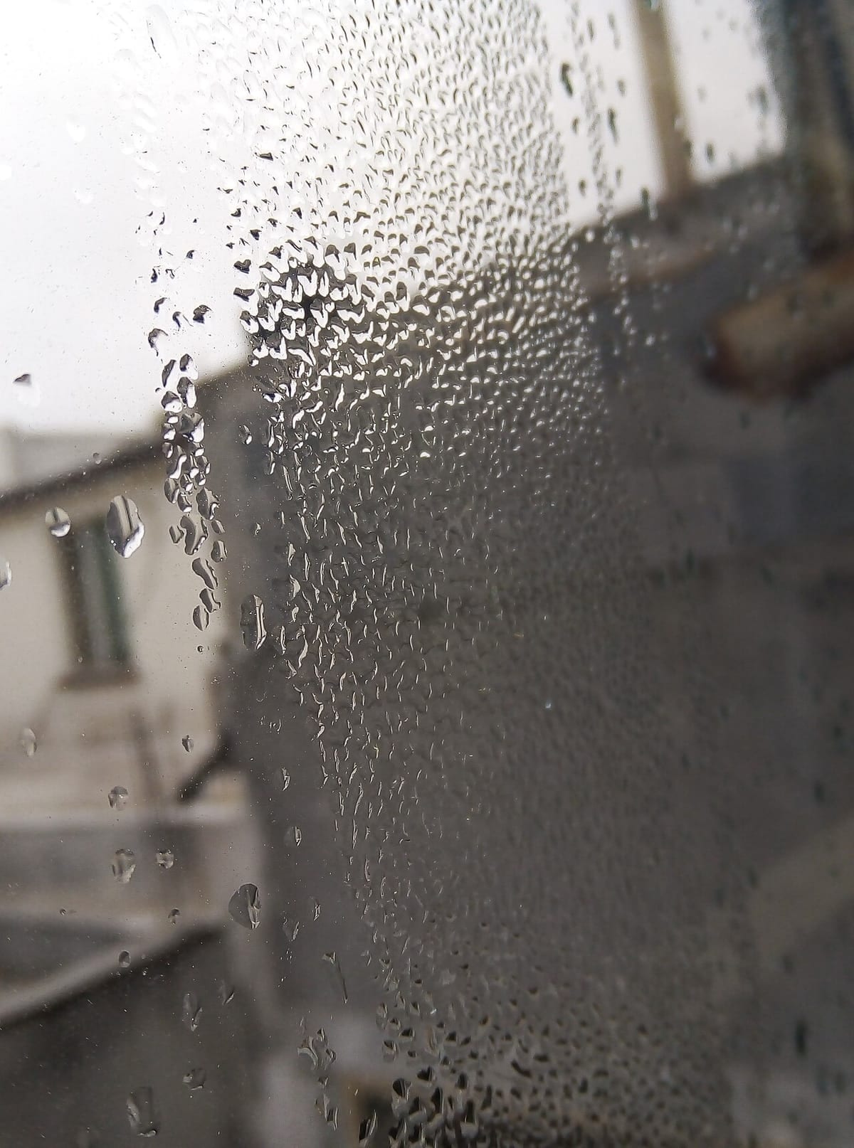 Water droplets running down the inside of a window pane