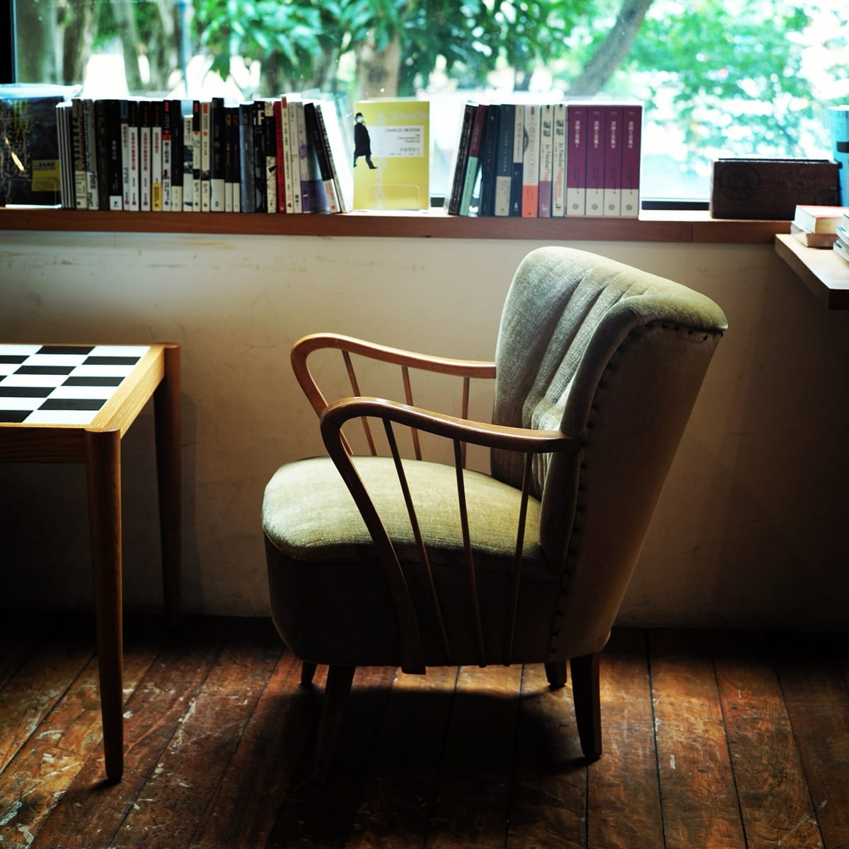 A room with wide wooden floorboards running toward a window