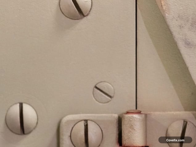 Close-up of hinge screws in a door hinge leaf